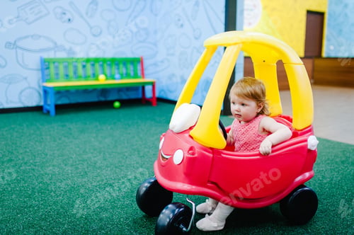 Preview: Happy children, little girl child rides on a red big car on the road. Close up. The baby is driving