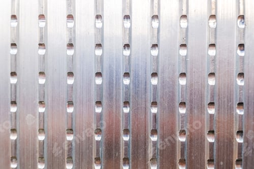 Preview: Metallic texture of an aluminum plate with slits for use as an industrial background.