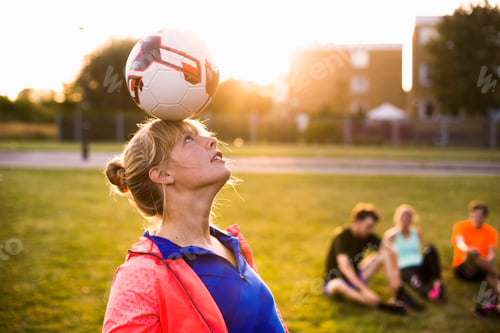 Preview: Sporty woman balancing ball on head at park