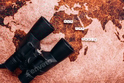 Preview: Black binoculars lies on the a geographical map