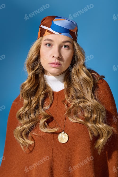Preview: A young plus size woman poses confidently against a vibrant blue background wearing bold colors
