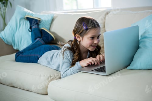 Preview: Young Girl Using Laptop Computer Lying on Couch