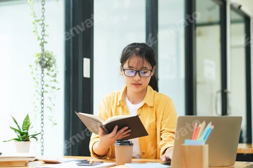 Preview: Serious young asian student reading a book preparing the exam.