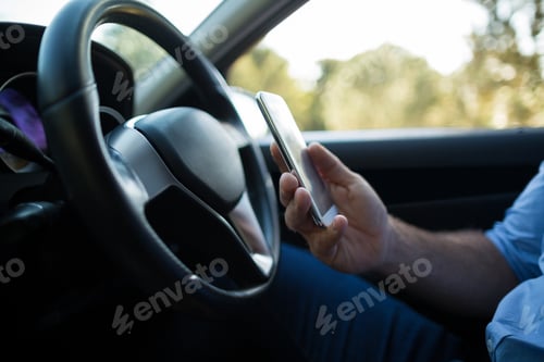 Preview: Man using mobile phone in car