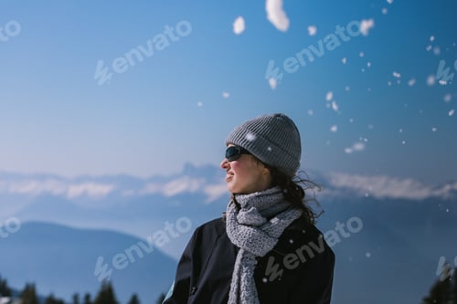 Preview: Woman on Winter vacation wearing a cap and sunglasses looking away