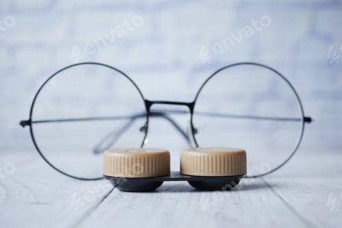 Preview: close up of Contact lens and eyeglass on table