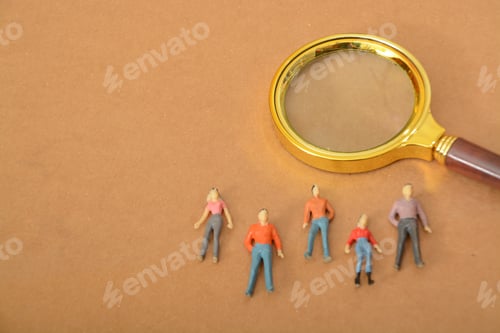 Preview: Magnifying glass and people figures. a magnifying glass revealing contributions of staff members