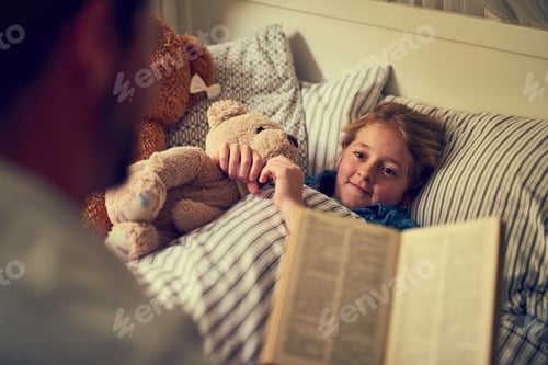 Preview: Cropped shot of a father reading a bedtime story to his little daughter at home