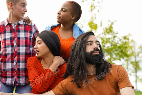 Preview: Group of multiracial people having fun talking together at city park