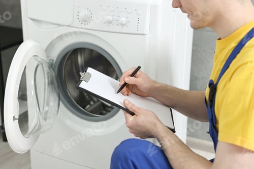 Preview: Plumber writing results of examining washing machine in bathroom, closeup