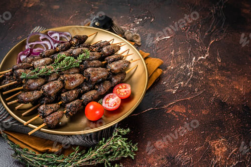 Preview: Grilled chicken heart on skewers on a steel plate. Dark background. Top view. Copy space