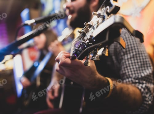 Preview: Man playing guitar with singer in the background