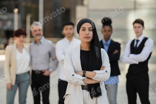 Preview: portrait of muslim arab businesswoman, and her team of workers outside - business concept -