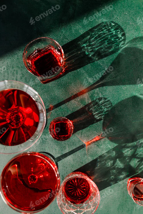 Preview: Creative beverage photography of red cocktail in different glasses under hard light