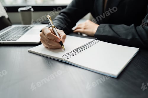 Preview: Business woman working in office writing plan on note book and use computer laptop meeting online