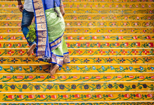 Preview: Scenic view of a woman walking up the temple stairs decorated with floral textures