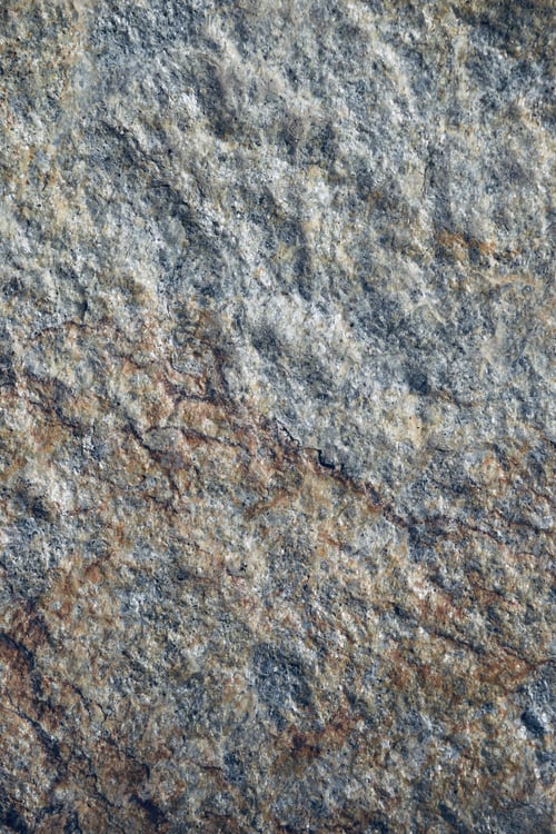 Preview: Vertical shot of a textured rugged stone with multi tones of color