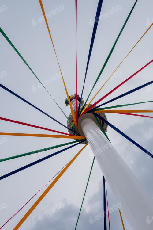 Preview: Low angle shot of a classic English Maypole during a dancing festival under a cloudy sky