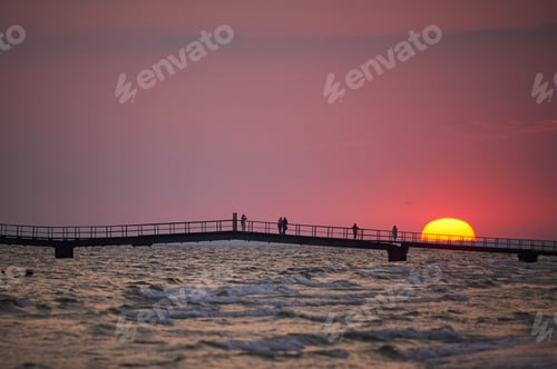 Preview: Colorful dawn over the sea. Pier on the horizon.