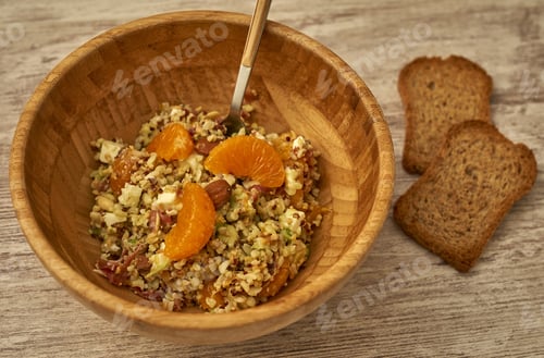 Preview: View of the quinoa salad with fresh tangerines on a wooden table