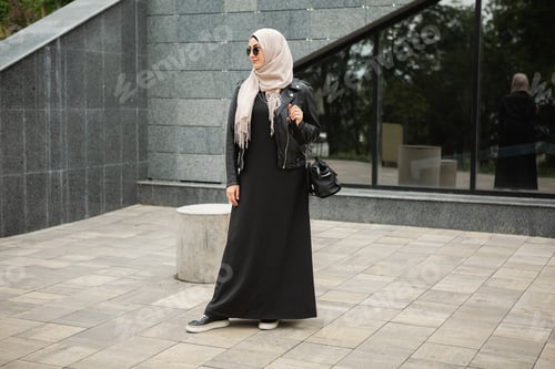 Preview: modern stylish muslim woman in hijab in city street
