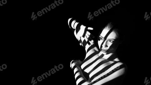 Preview: Naked Woman Posing With Striped Shadows in a Dark Room