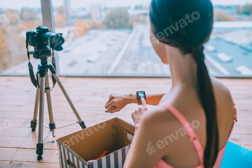 Preview: Woman taking smart watch after unpacking box with presents