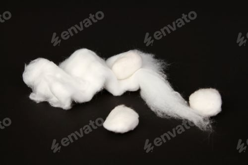 Preview: Closeup shot of white cotton balls isolated on black background