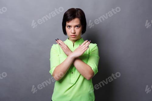 Preview: Young Woman Making Stop Sign With Crossed Hands. Serious Girl Denying, Refusing Any Action, Looking