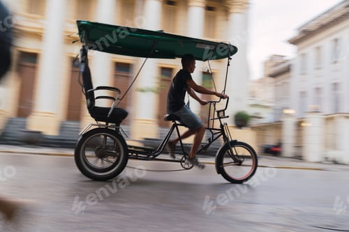 Preview: LA HABANA, CUBA - NOVEMBER, 6 , 2018: Hispanic man cycling rickshaw on street