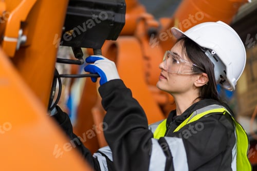 Preview: A team of female engineers meeting to inspect computer-controlled steel welding robots.