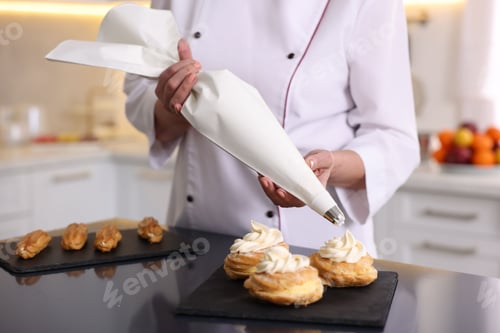 Preview: Professional pastry chef making desserts at table in kitchen, closeup