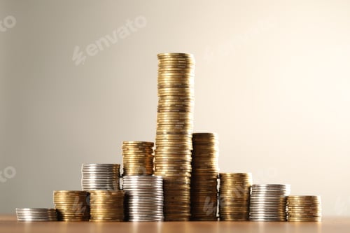 Preview: Stacks of coins on table against light grey background, closeup