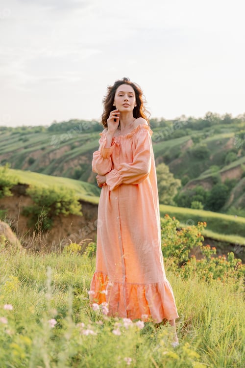 Preview: Pretty girl in a beautiful dress walks in a field and smiles sincerely