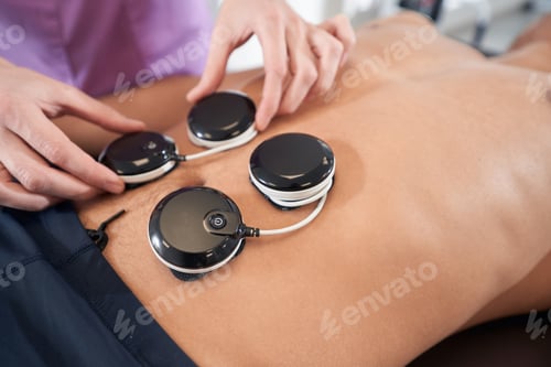 Preview: Man receiving myostimulation treatment in physical therapy clinic