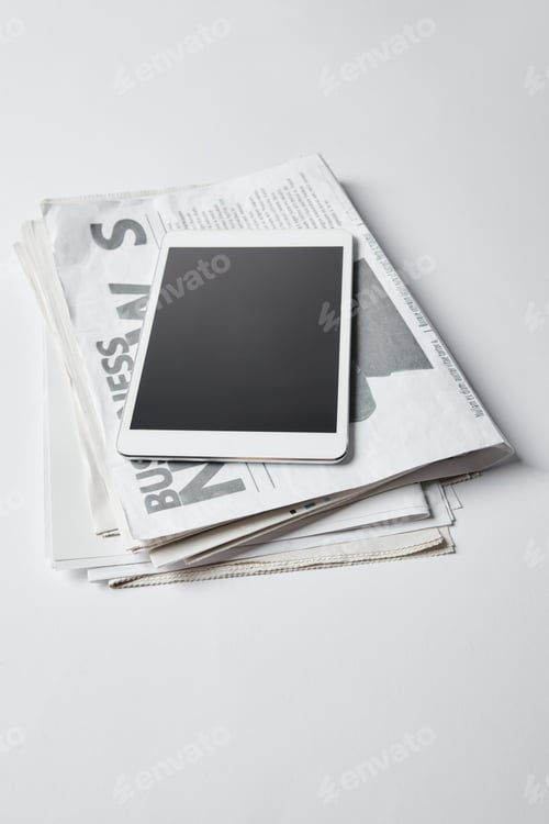 Preview: digital tablet with blank screen on business newspapers on white