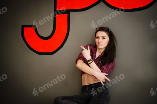 Vista previa: Brunette street dancer girl wearing casual clothes background gray wall with some graffiti.