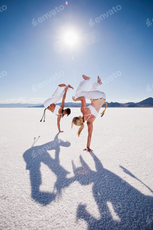 Visualização: Duas mulheres praticando capoeira em Bonneville Salt Flats, Utah, EUA