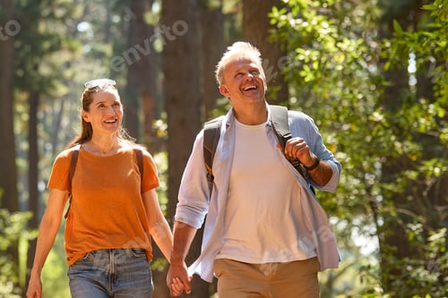 Preview: Senior Retired Couple Holding Hands Hiking Along Trail In Countryside