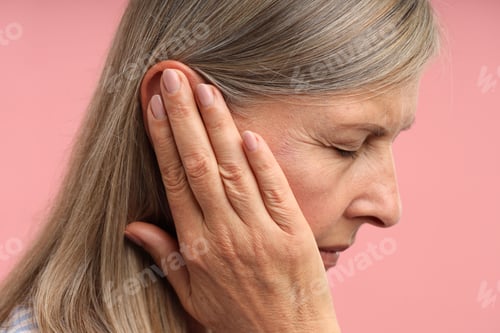 Preview: Sound. Senior woman touching her ear on pink background