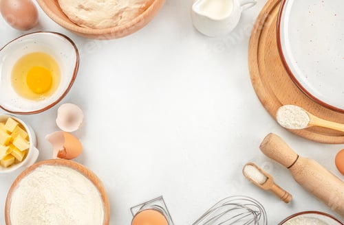 Preview: Baking Cooking Ingredients Flour, eggs, sugar, spices, and a whisk on the kitchen table.