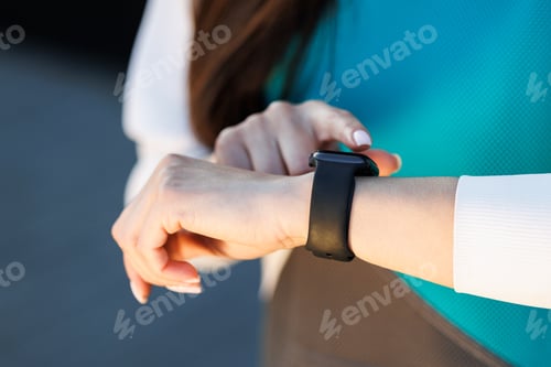 Preview: Woman uses a smart watch to measure the pulse on the hands. A woman does sports on the street