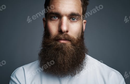 Preview: Bearded young hipster standing against a gray background