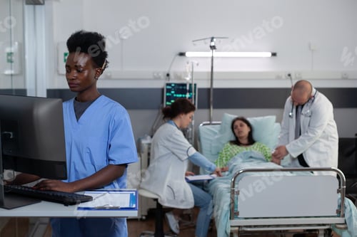 Preview: Nurse using computer to read patient medical history and lab results in hospital ward