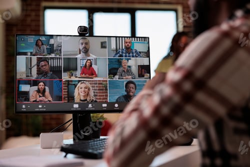 Preview: Closeup of computer screen with startup team of colleagues working remote in group video call