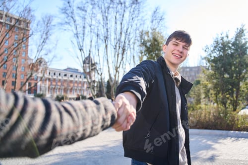 Preview: Smiling Man Holds Hand in Urban Setting