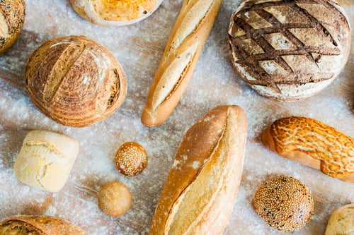 Preview: Large variety of wholemeal and white bread rolls and loaves, overhead view