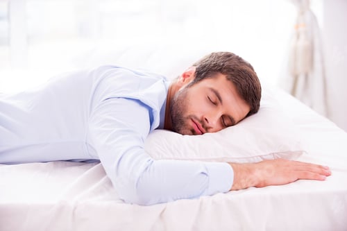 Preview: Tired and overworked. Handsome young man in shirt sleeping in bed
