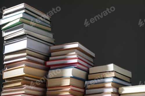 Preview: Many stacked books against grey background, closeup. Space for text