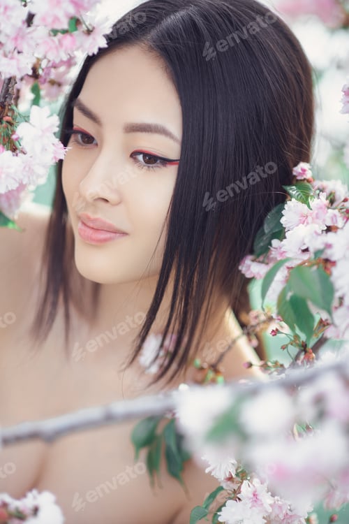 Preview: Portrait of a beautiful fantasy asian girl outdoors against natural spring flower background